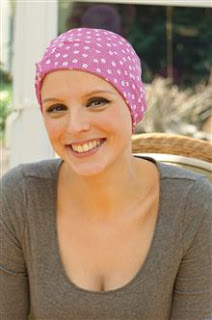 girl smiling wearing pink and white chemo sleep hat