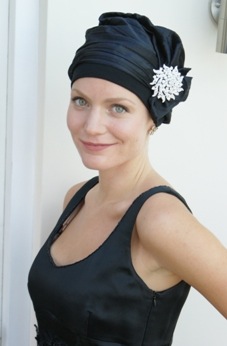 woman wearing black evening cocktail chemo hat with crystal brooch