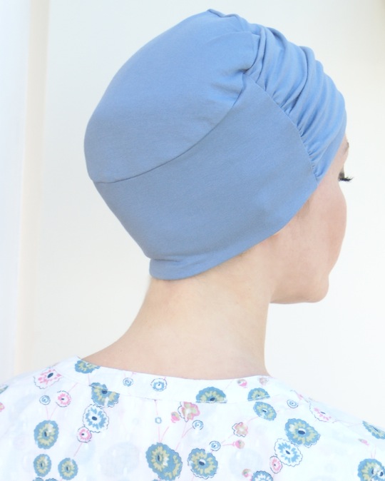 back view of woman wearing blue chemo beanie