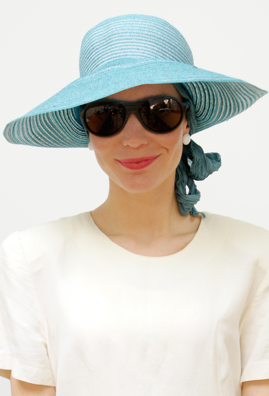 blue straw summer hat on woman wearing sunglasses