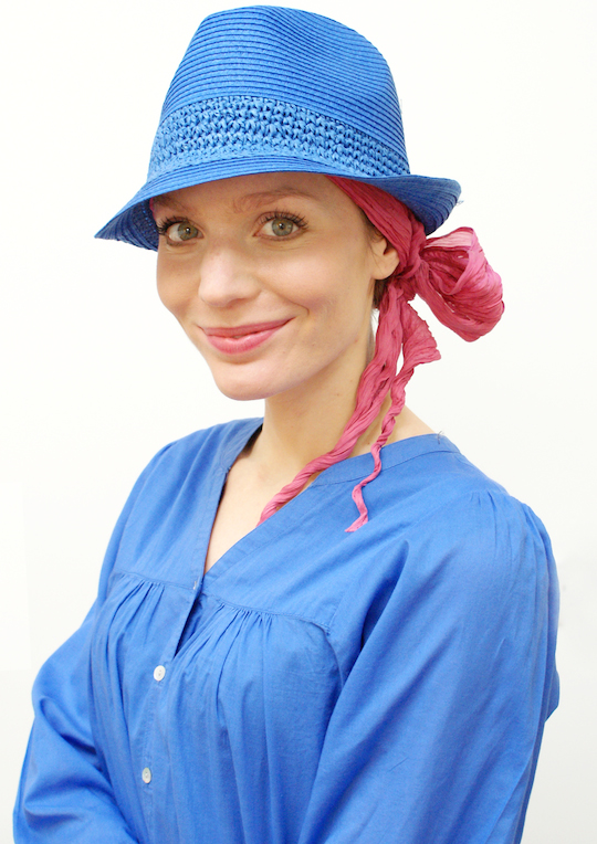 blue summer hat worn over pink headscarf on woman