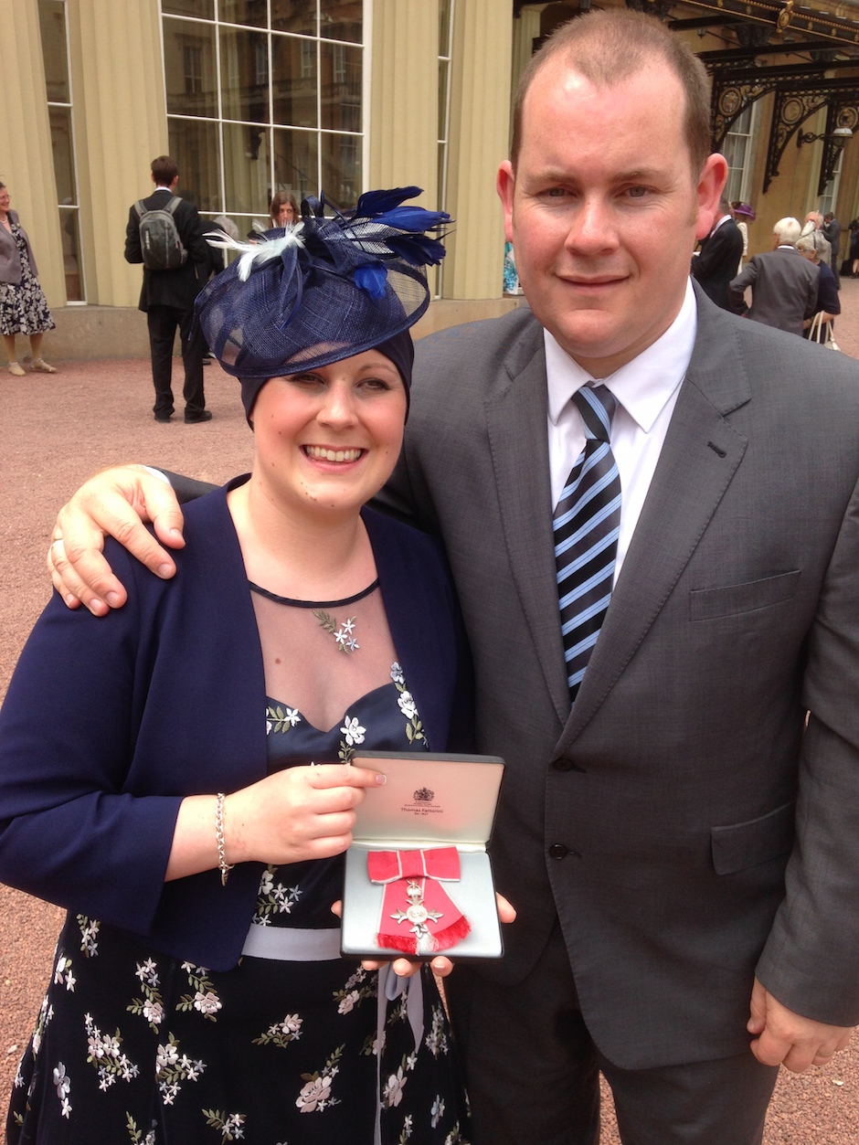 doctor with her husband receiving MBE at Buckingham Palace