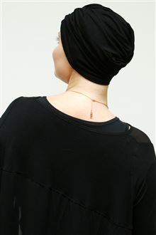 Back view of black turban worn with black evening dress