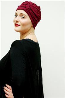 Dark red evening turban worn with red lipstick and black evening dress