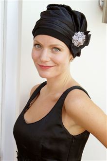 Black satin turban with crystal pin on woman wearing a black evening dress