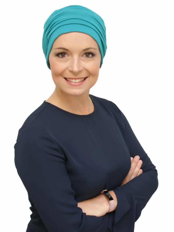 teal chemo hat on young woman