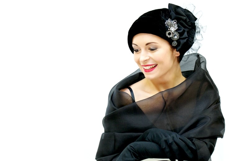 young woman smiling in black cocktail hat