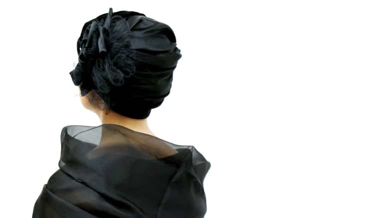 back view of black cocktail hat worn by young woman