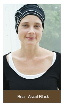 woman standing wearing black and white chemo hat