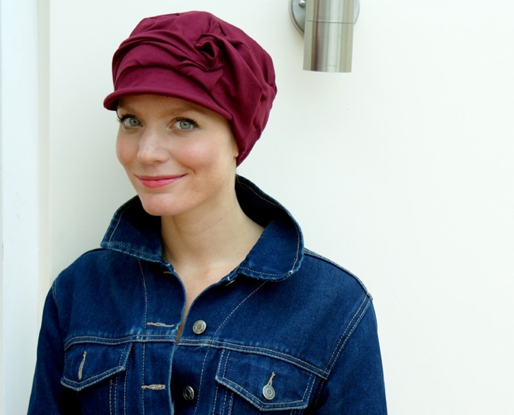 red chemotherapy cap for hair loss worn by young woman