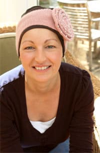 woman wearing pink wide headband over chemo beanie