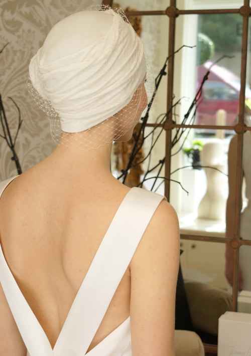 Back view of bride wearing ivory chemo turban and veil