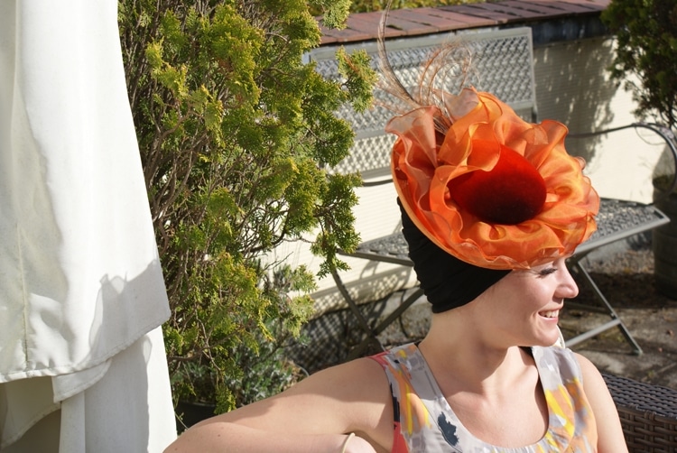 woman wearing chemo turban under Ascot hat