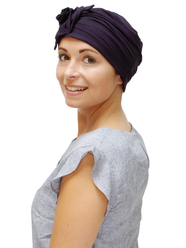 young woman wearing wine coloured chemo hat
