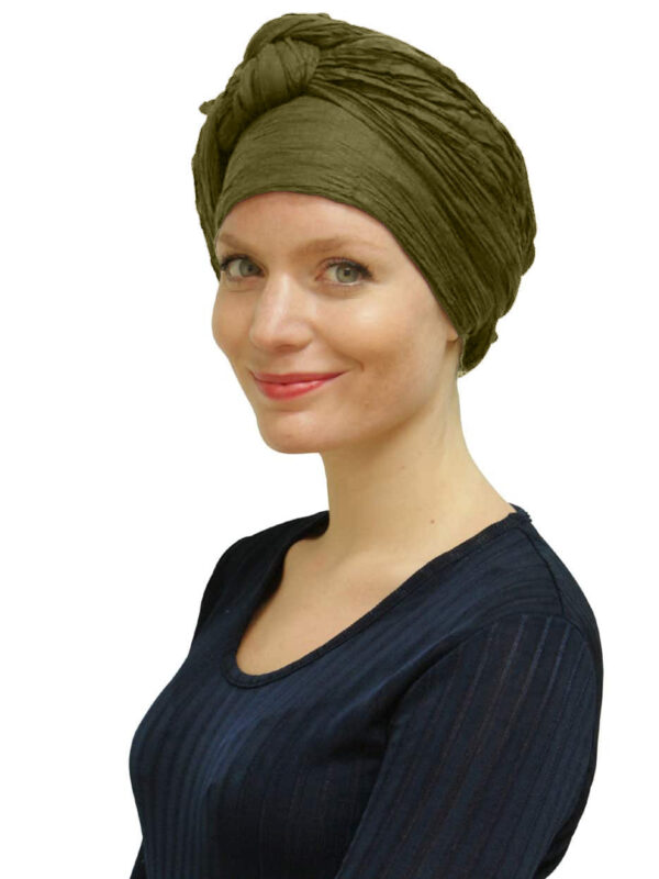 young woman wearing long green scarf as a turban
