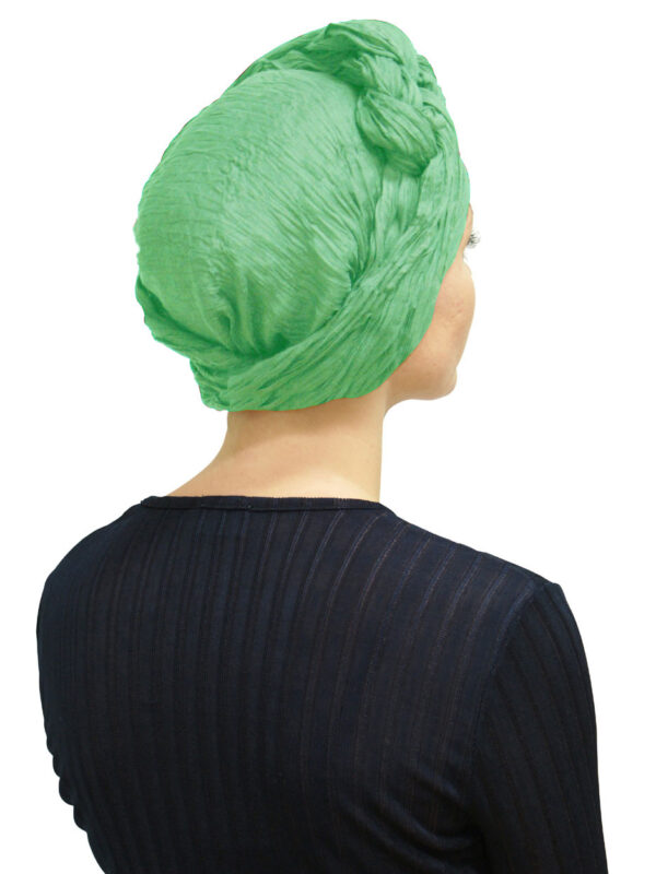Back of woman's head wearing green headscarf as a turban