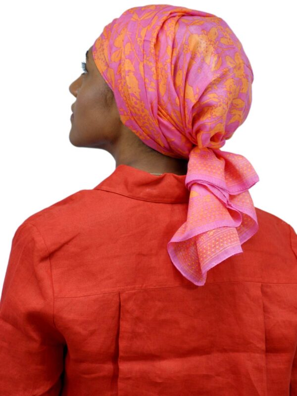 back of woman wearing an orange floral chemo scarf as a turban