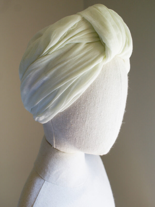 Cream head scarf worn as turban on mannequin