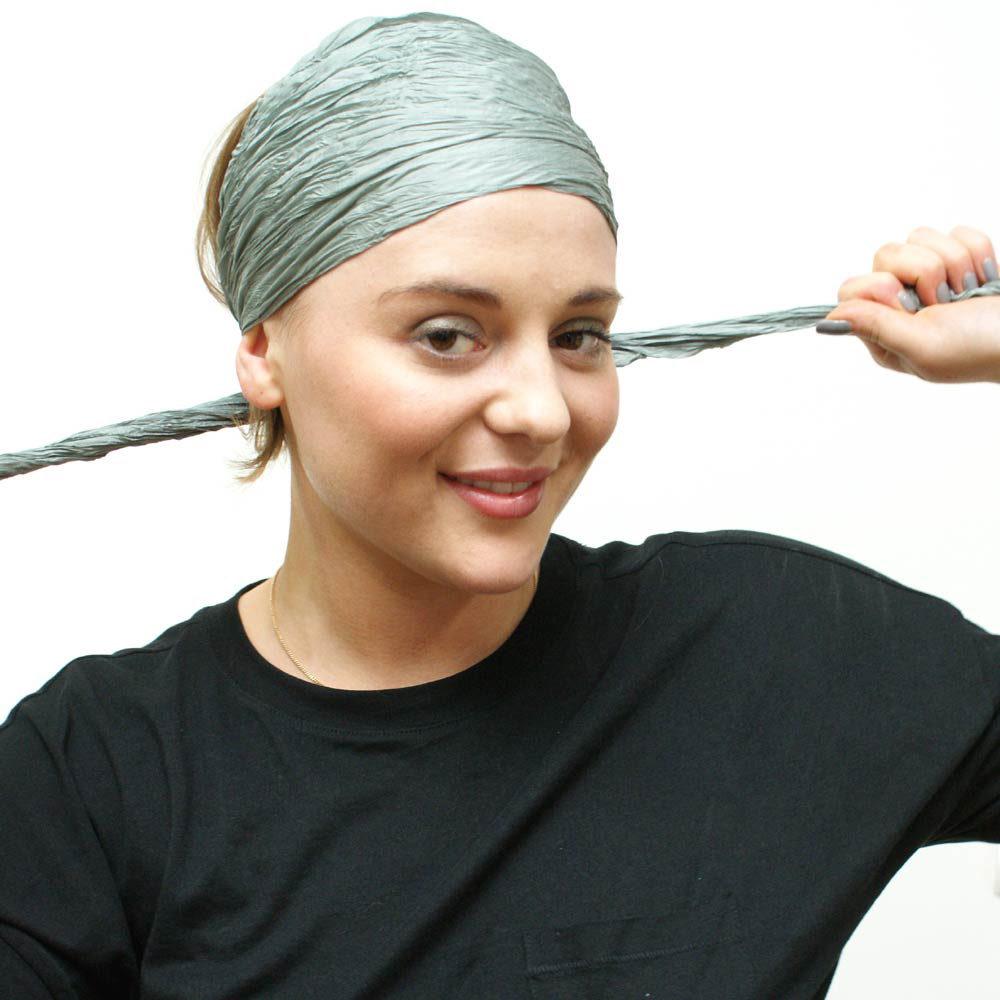 Front view of silk headband scarf being tied, ends brought round to forehead